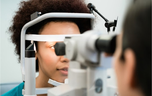 Young woman at the optometrist's clinic being examined with a refractor during a comprehensive eye exam by the optometrist.