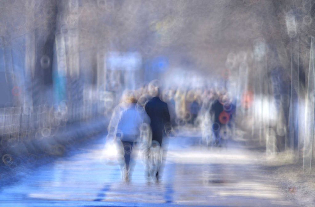Image of a blurry view of people walking in a park, a potential retinal detachment symptom.