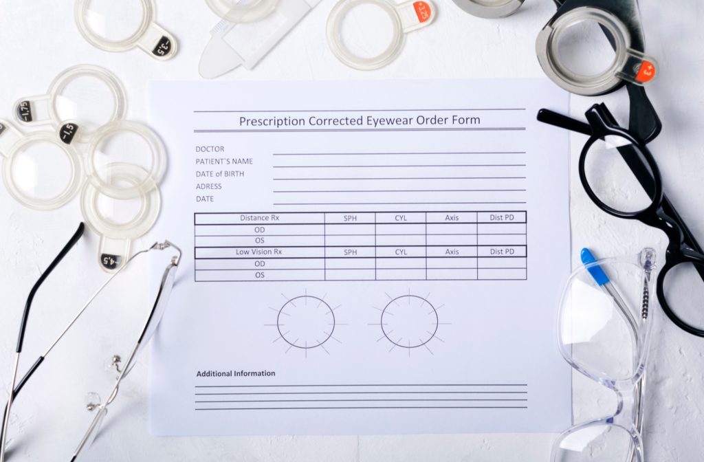 A prescription eyewear order form surrounded by various lenses and frames.
