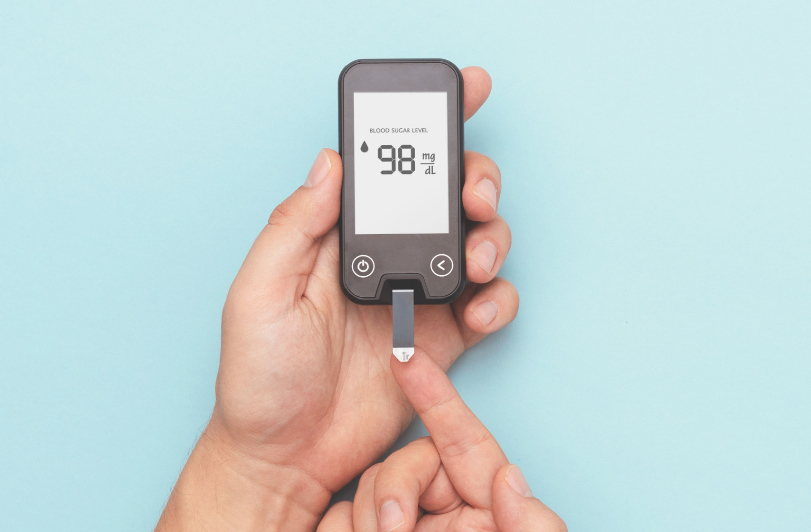 Pair of hands using a glucometer.