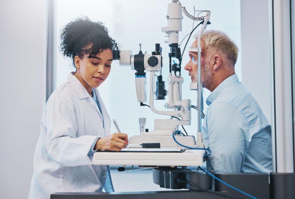 A senior male getting a slit lamp exam with his optometrist during his annual eye exam.