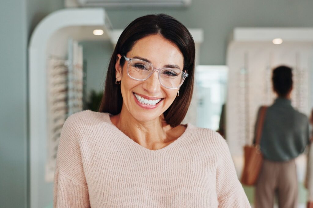 Smiling woman in her 40s wearing a pair of fashionable glasses.